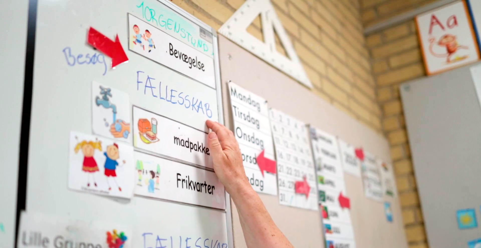 Tavlen i børnehaveklassen på Tilst Skole, en finger peger på teksten Fællesskab